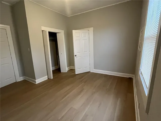 an empty room with wooden floor and window