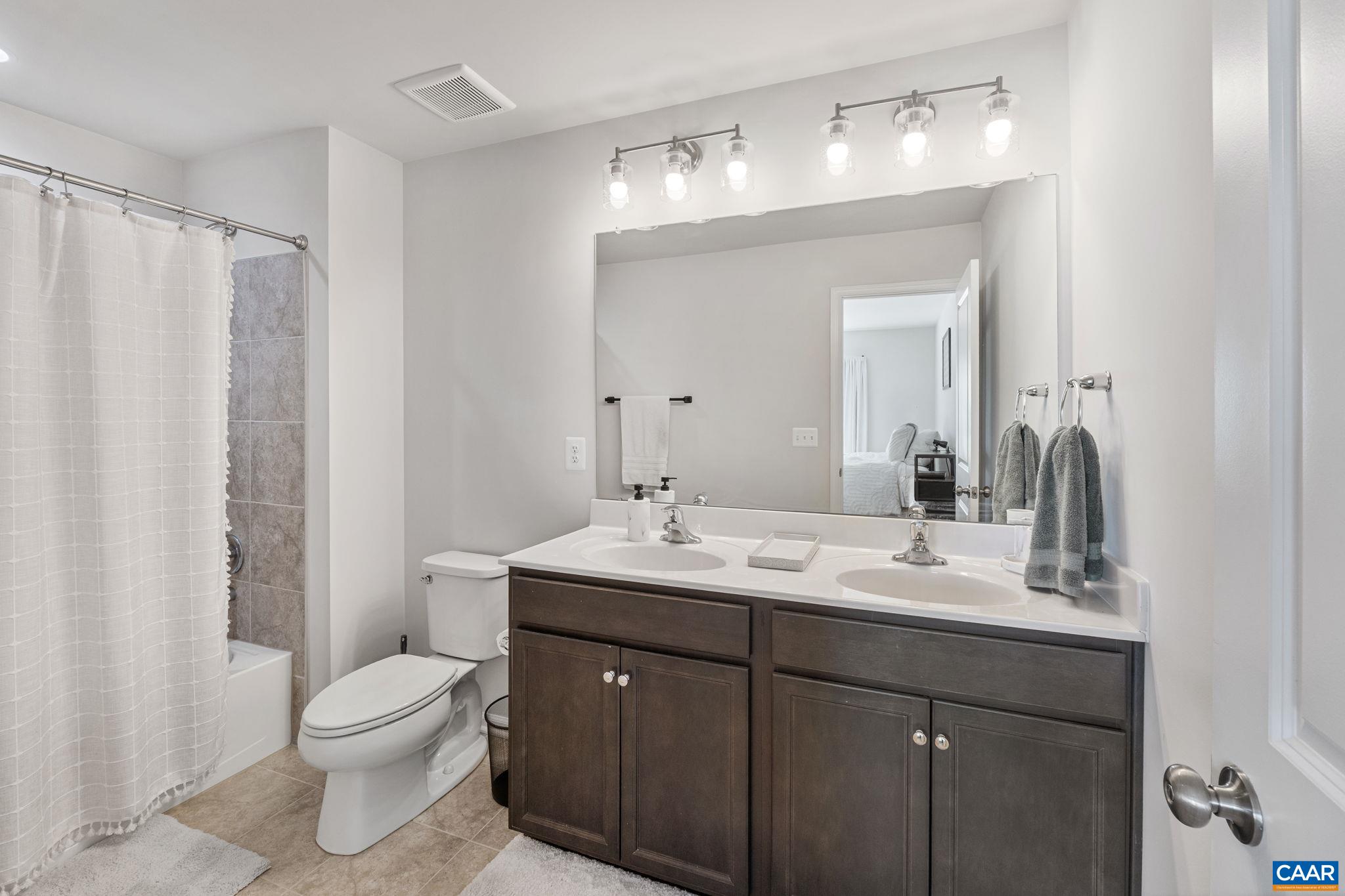 124 Shady Court Waynesboro, VA 22980 - Photo 17 of 32 a bathroom with a double vanity sink toilet mirror and shower