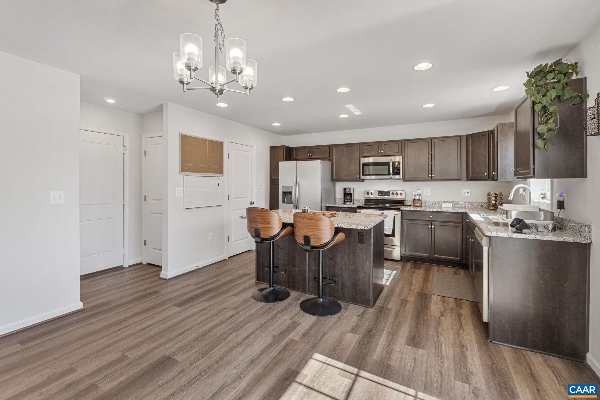124 Shady Court Waynesboro, VA 22980 - Photo 7 of 32 a open kitchen with stainless steel appliances granite countertop a stove top oven a sink dishwasher a dining table and chairs with wooden floor
