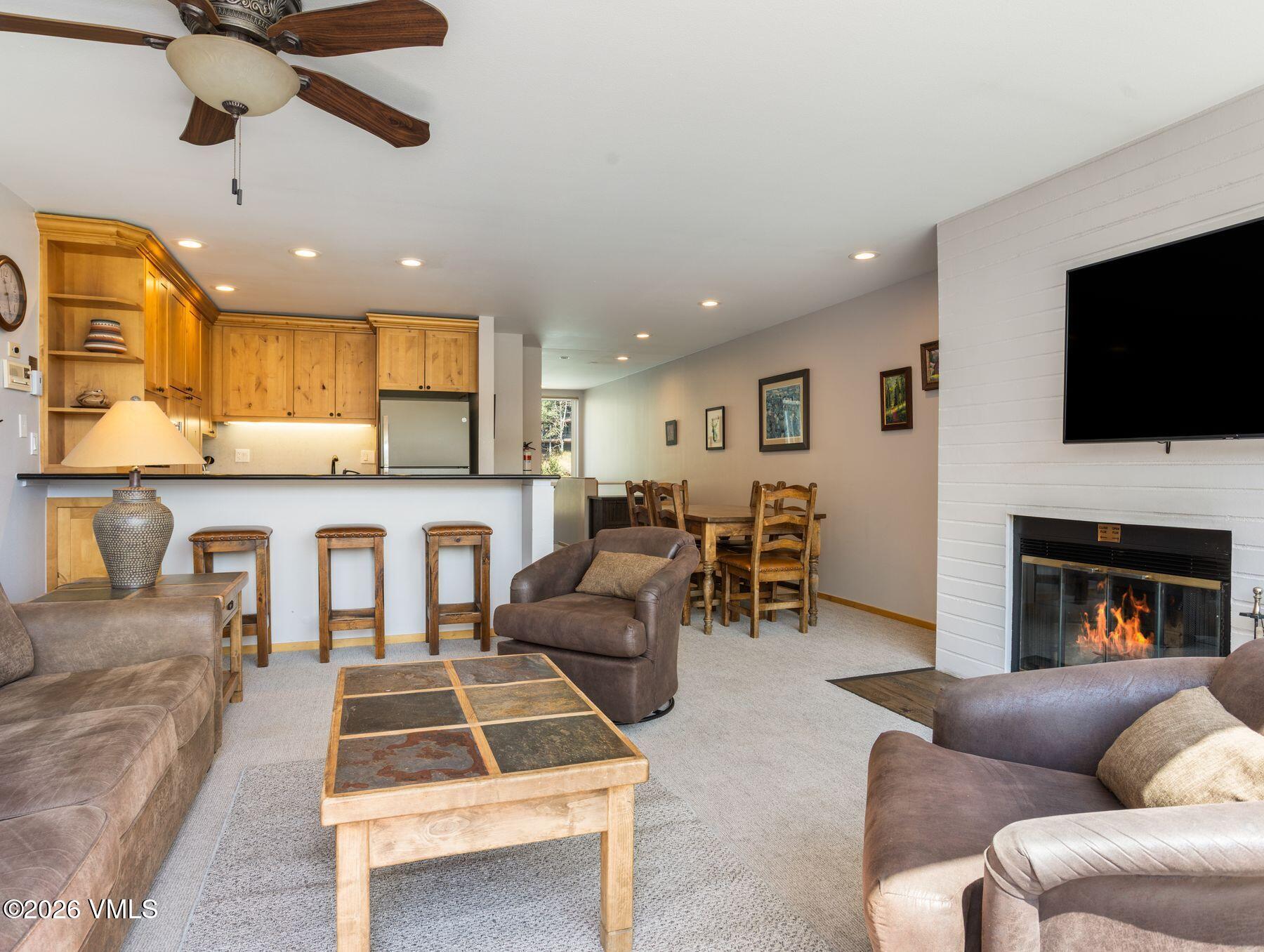 1100 North Frontage Road West, Unit 1503 Vail, CO 81657 - Photo 13 of 32 a living room with furniture a flat screen tv and a fireplace