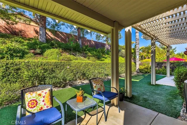 a view of a swimming pool with a lawn chairs and palm trees