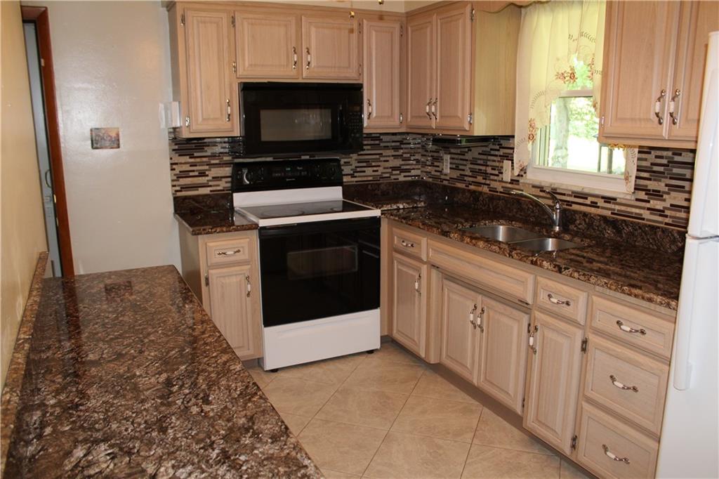 928 Old Ridge Road Avella, PA 15312 - Photo 22 of 49 a kitchen with granite countertop white cabinets and stainless steel appliances