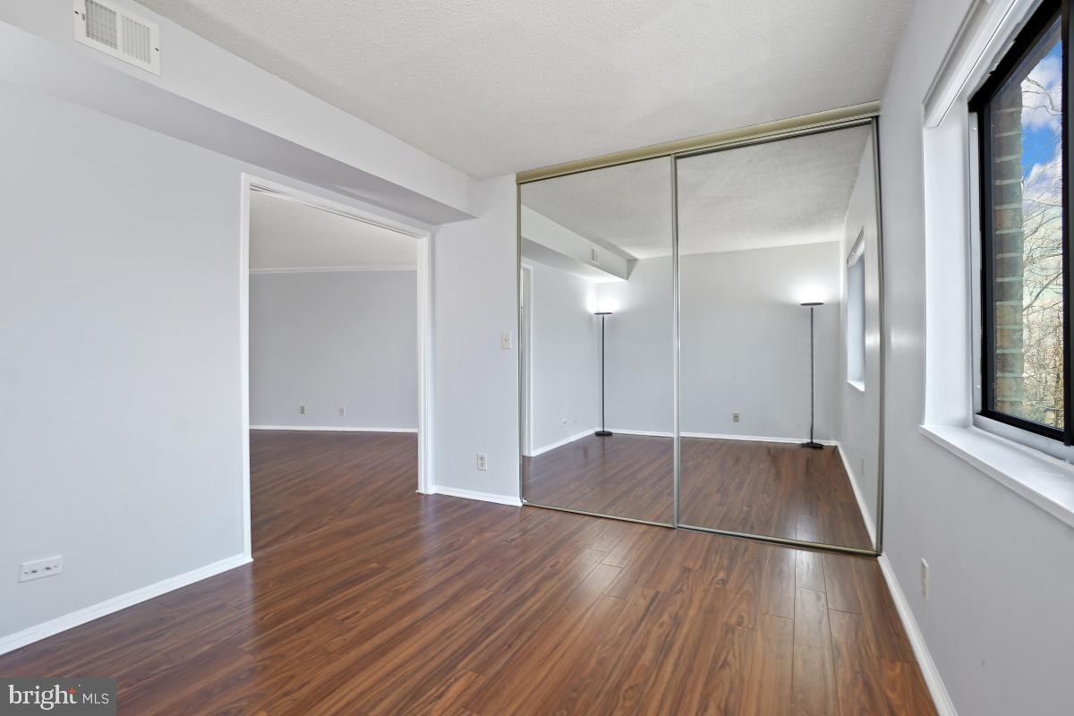 5903 Mt Eagle Drive, Unit 314 Alexandria, VA 22303 - Photo 39 of 44 an empty room with wooden floor and windows