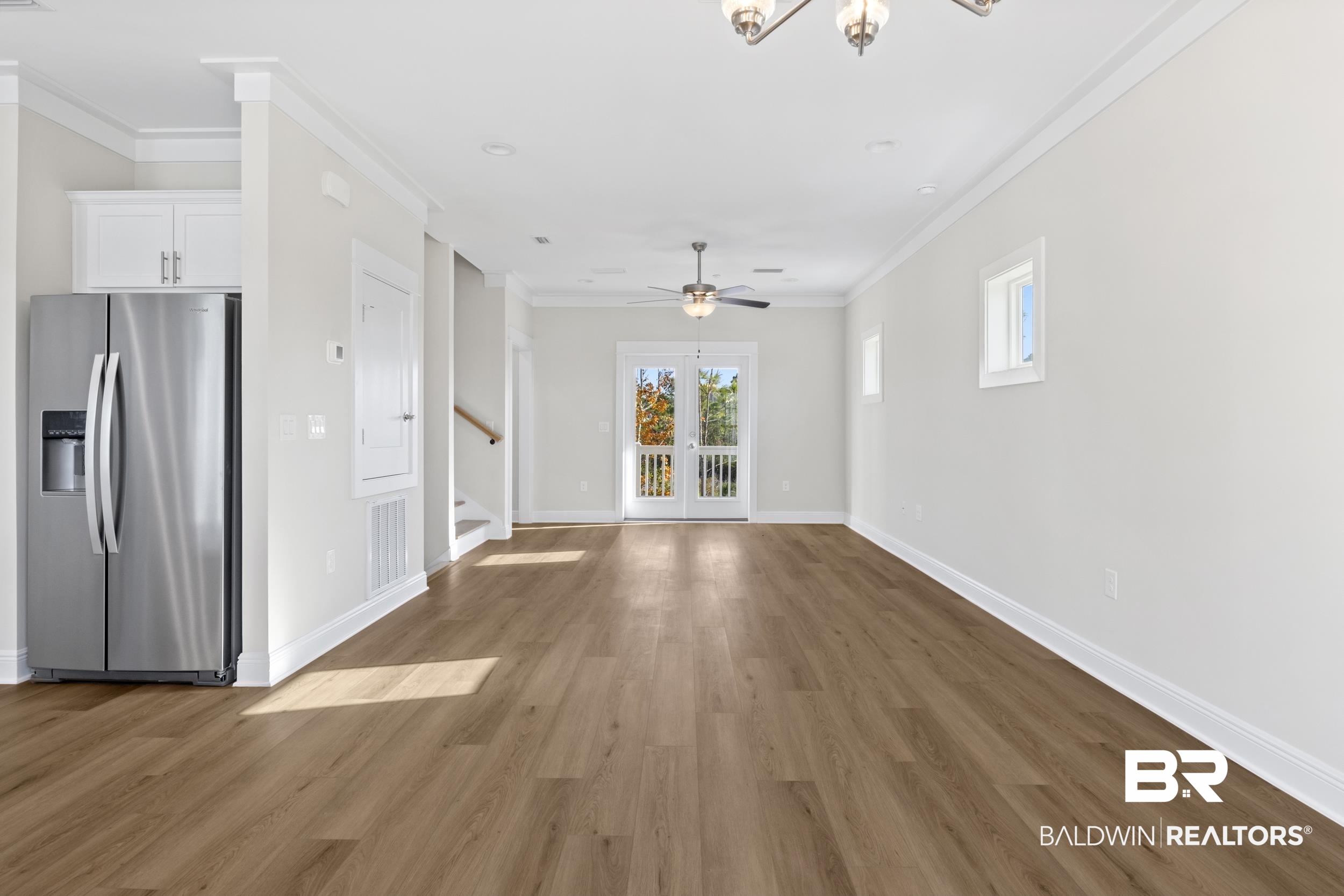 2847 Salt Drive Orange Beach, AL 36561 - Photo 7 of 29 Unfurnished living room with hardwood / wood-style floors, ceiling fan with notable chandelier, and crown molding