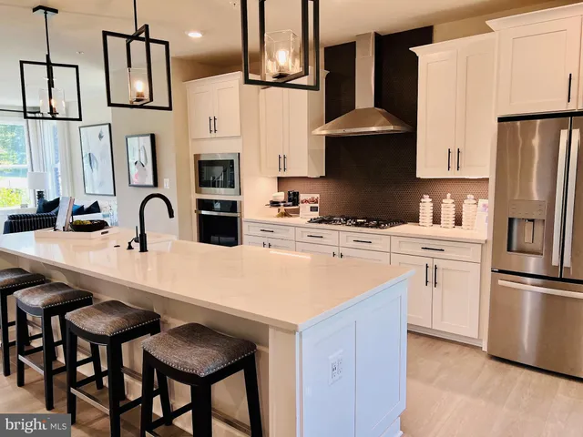 a kitchen with stainless steel appliances a stove a sink and a refrigerator