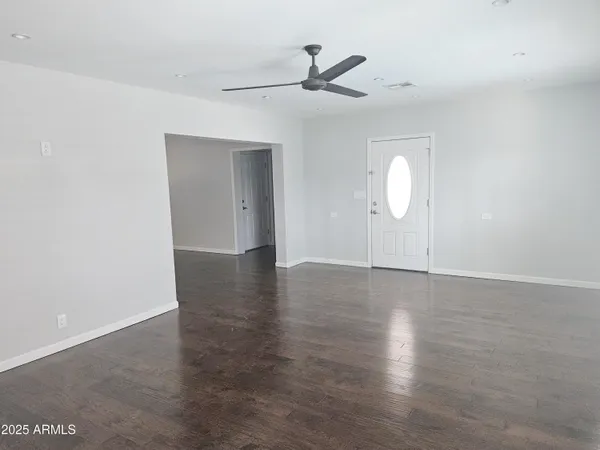 a view of a livingroom with wooden floor and a ceiling fan