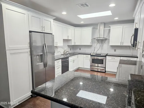 a kitchen with stainless steel appliances granite countertop a refrigerator sink and cabinets