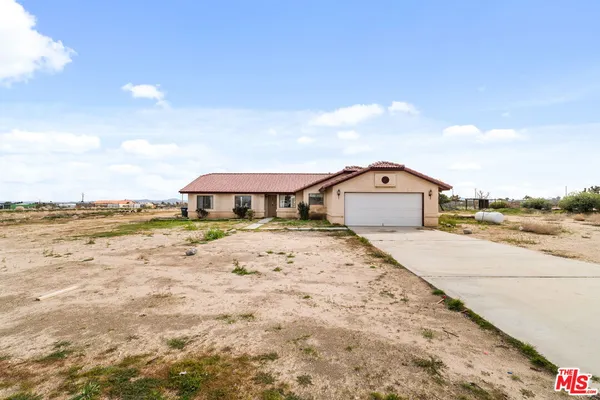 a front view of a house with a yard and ocean