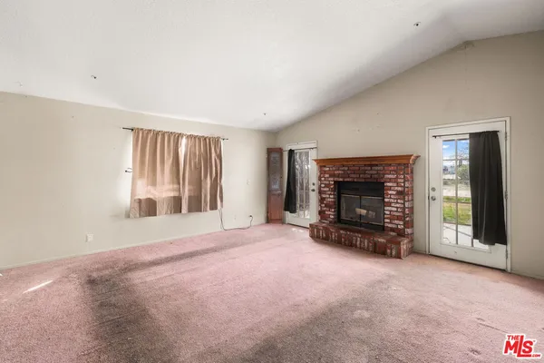 an empty room with fireplace and window