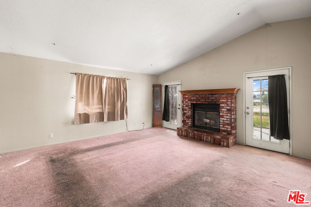 13377 Paramount Road Phelan, CA 92371 - Photo 12 of 28 an empty room with fireplace and window