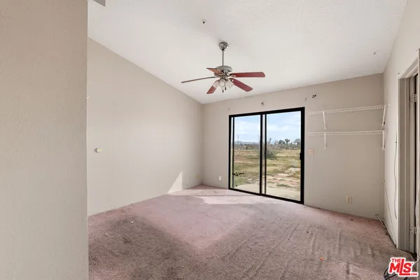 a view of a room with a ceiling fan and closet