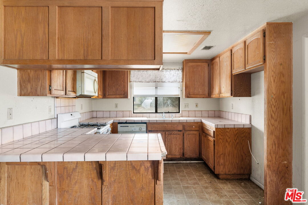 13377 Paramount Road Phelan, CA 92371 - Photo 7 of 28 a kitchen with a sink stove and cabinets