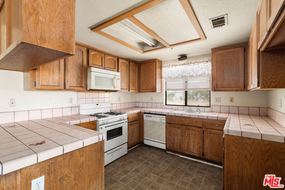 13377 Paramount Road Phelan, CA 92371 - Photo 8 of 28 a kitchen that has a sink and a stove in it