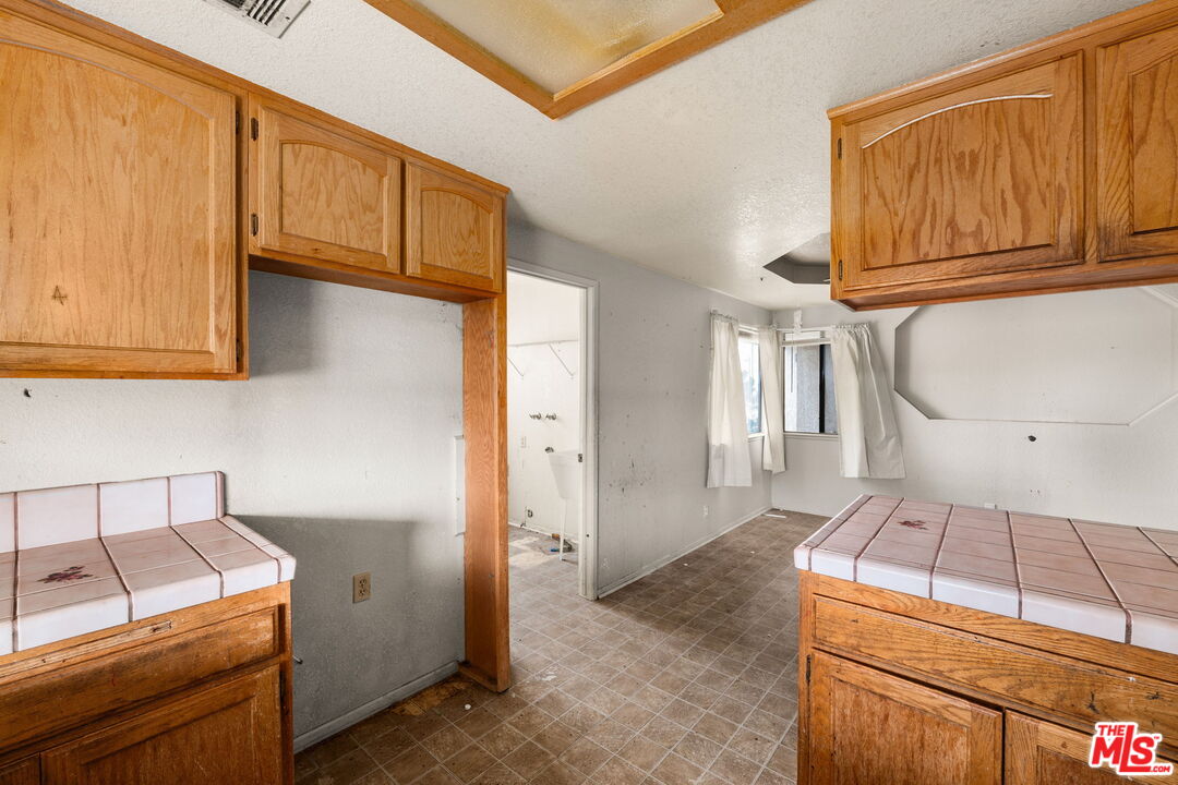 13377 Paramount Road Phelan, CA 92371 - Photo 9 of 28 a kitchen with wooden cabinets and a stove top oven