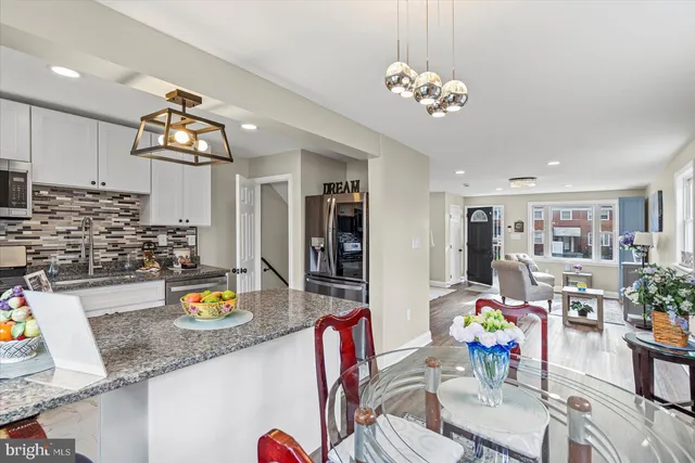 a kitchen with a sink dishwasher and a dining table with kitchen view