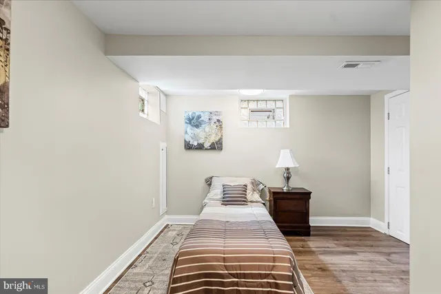 a view of a bedroom with wooden floor and bed