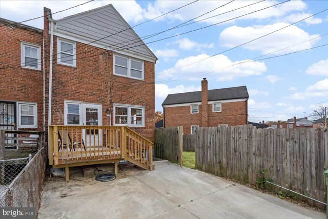 a view of a house with a wooden deck and furniture