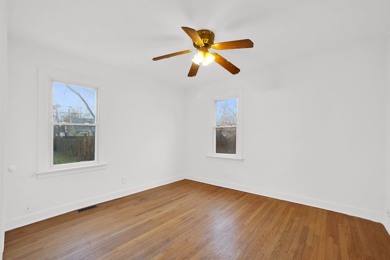 15014 Ridgeway Avenue Midlothian, IL 60445 - Photo 4 of 18 a view of an empty room with wooden floor and a window