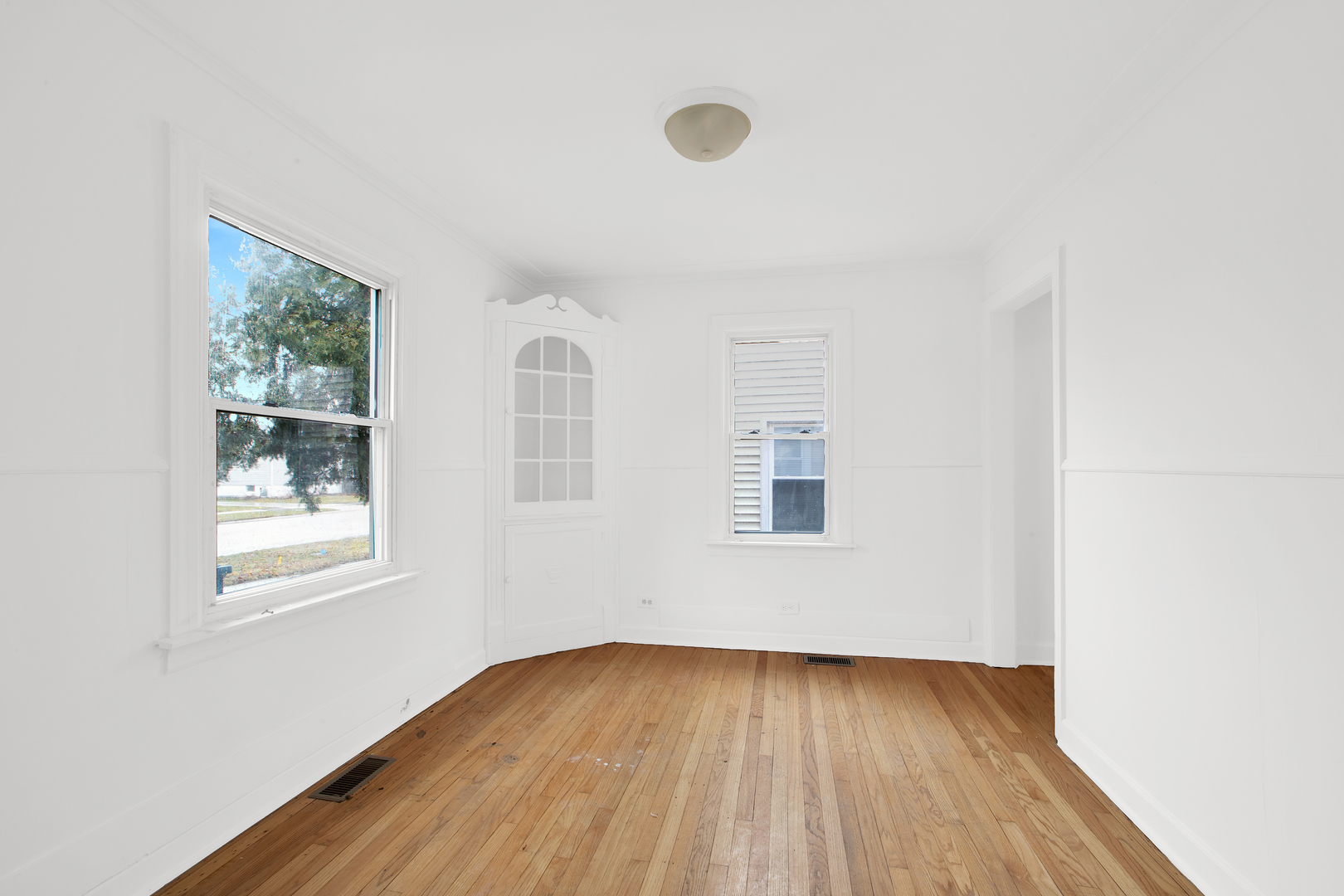 15014 Ridgeway Avenue Midlothian, IL 60445 - Photo 8 of 18 an empty room with wooden floor and windows