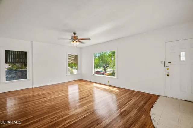 a view of empty room with wooden floor
