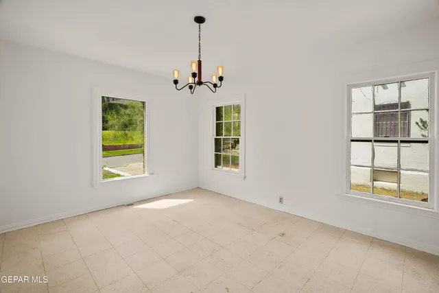 an empty room with windows and cabinet