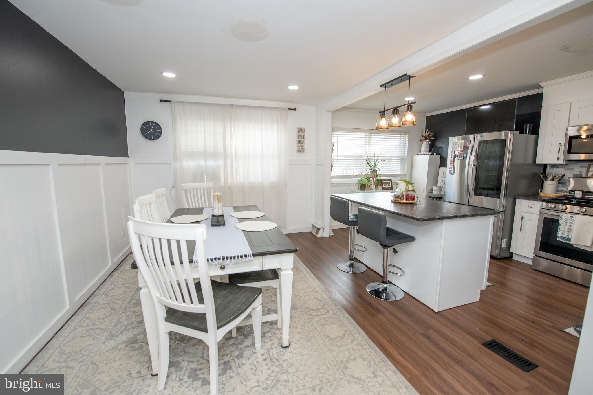 3141 Belgreen Road Philadelphia, PA 19154 - Photo 12 of 51 a dining room with kitchen island stainless steel appliances furniture a large window and a refrigerator