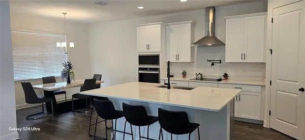 a kitchen with a table chairs sink and cabinets