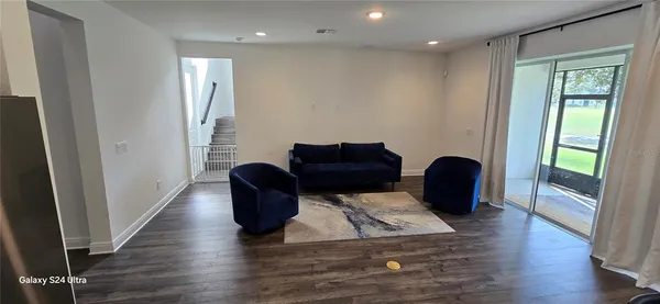 a living room with furniture and wooden floor