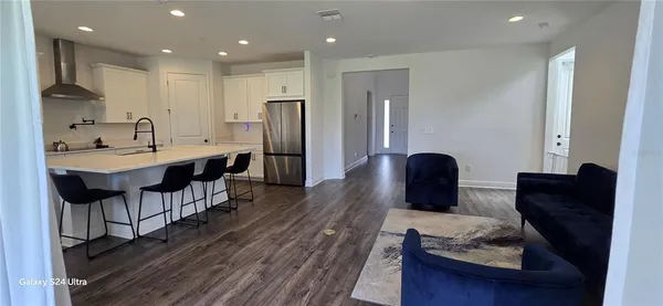 a kitchen with stainless steel appliances granite countertop a refrigerator a sink and a microwave