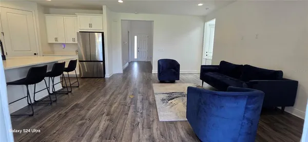a living room with furniture windows and a wooden floor