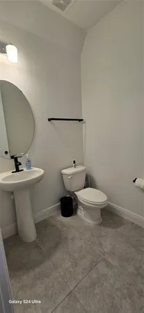 a white toilet sitting next to a bathroom sink