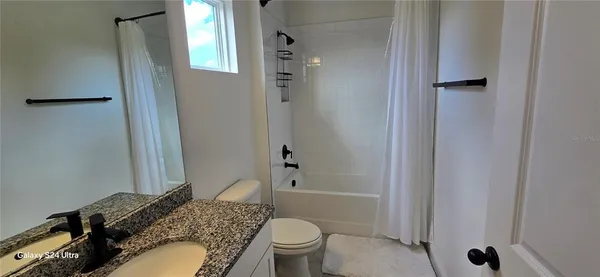a bathroom with a granite countertop toilet sink and shower