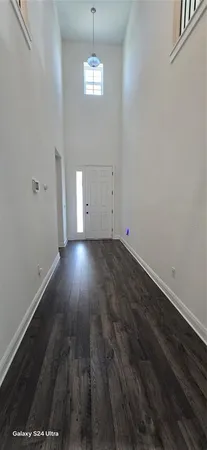 an empty room with wooden floor and chandelier