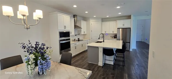 a kitchen with kitchen island a sink stainless steel appliances and wooden floor