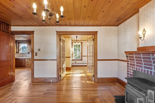 a view of a hallway with wooden floor and a dining room