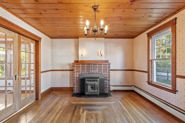 a view of an empty room with a fireplace and a window