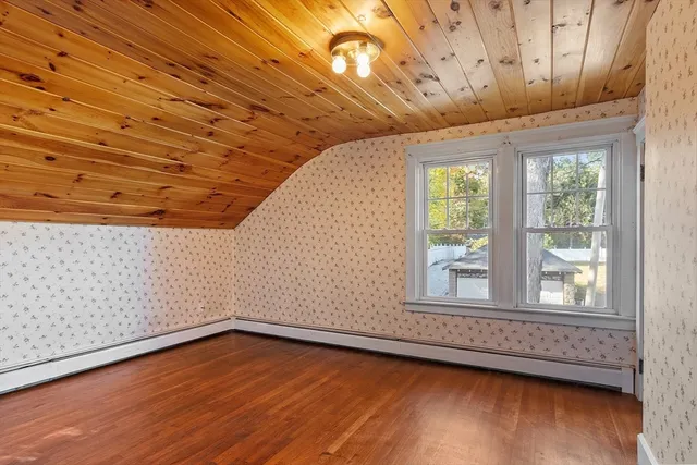 a view of a big room with wooden floor and windows