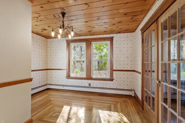 a view of a room with a large window and wooden floor