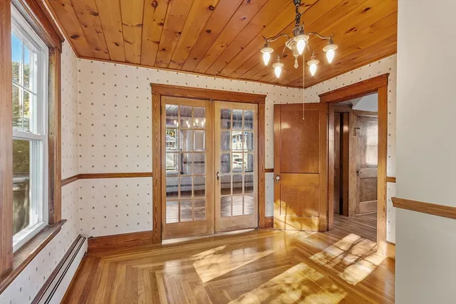a view of a hallway with wooden floor and a bathroom
