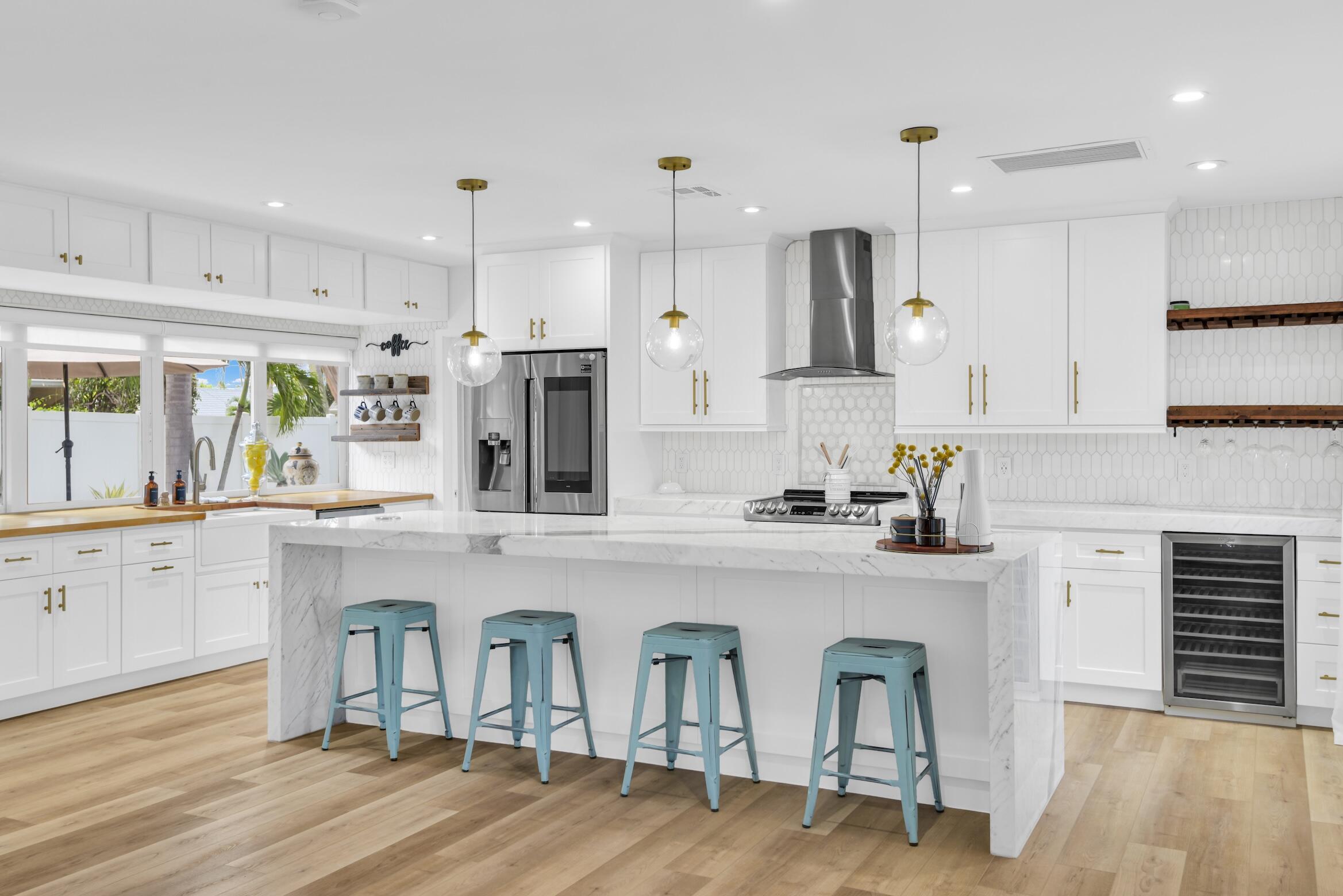 701 Appleby Street Boca Raton, FL 33487 - Photo 5 of 47 a kitchen with stainless steel appliances granite countertop a refrigerator a sink dishwasher a stove and white cabinets with wooden floor