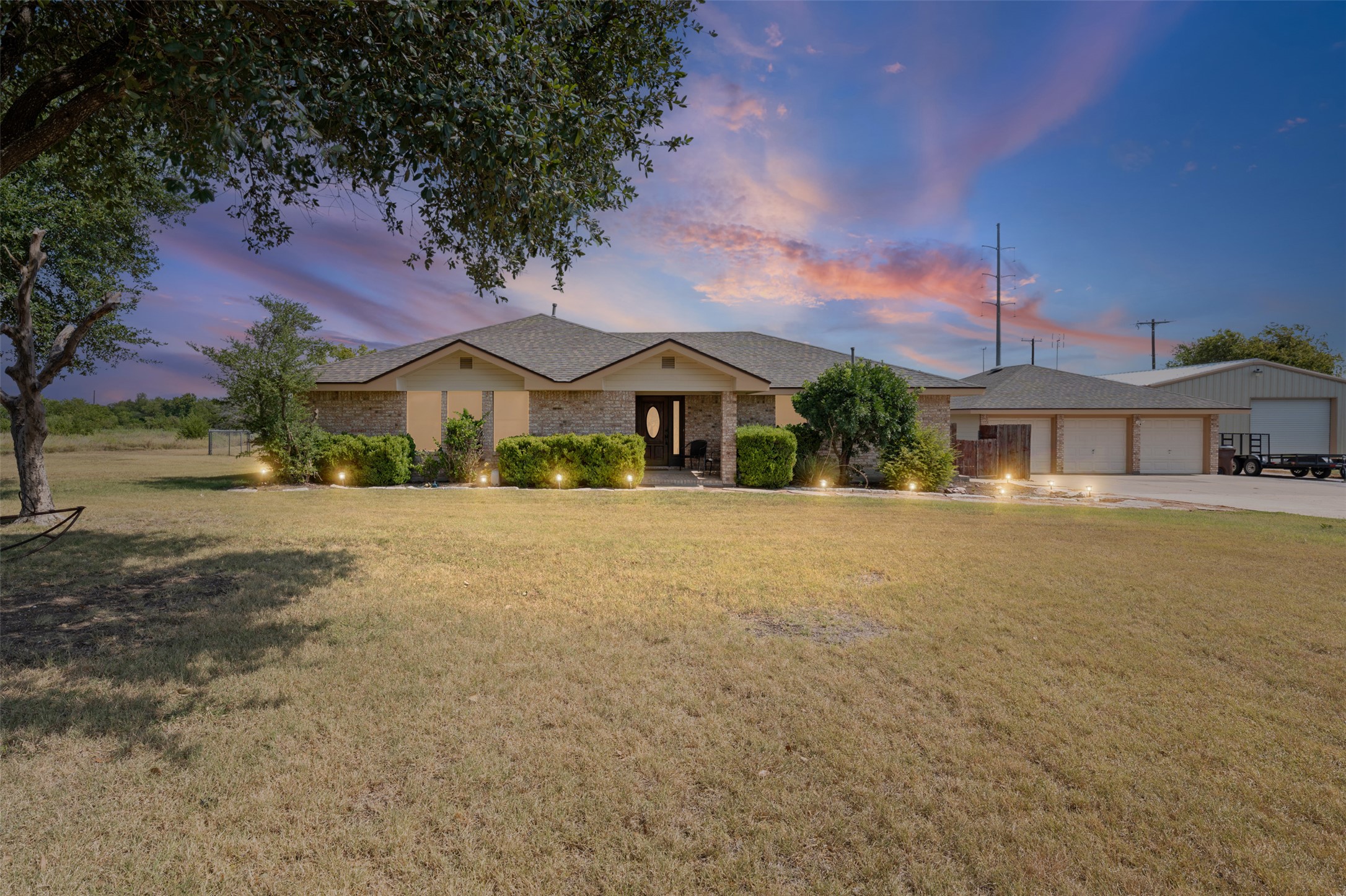 1512 Panther Loop Pflugerville, TX 78660 - Photo 1 of 40 A sprawling estate with a stone and stucco facade, complemented by a triple-bay garage and lush landscaping.