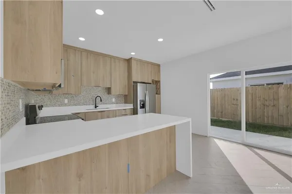 a large kitchen with kitchen island a sink stainless steel appliances and cabinets