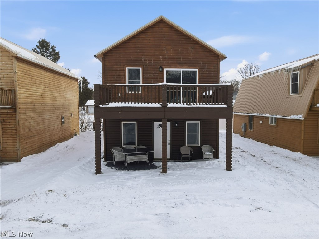 5919 Lake Road West, Unit 33 Ashtabula, OH 44004 - Photo 2 of 22 Snow covered house with a wooden deck, faux log siding, and a patio area