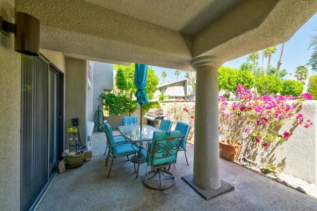 a view of a porch with chairs and potted plants