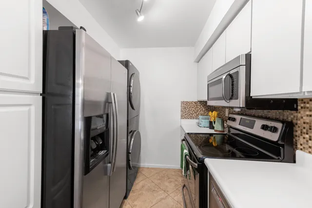 a kitchen with a refrigerator and a stove top oven