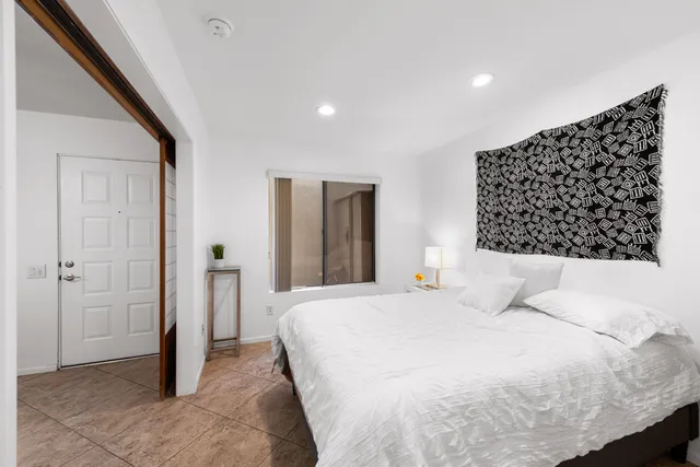 a bedroom with a large bed and a chandelier