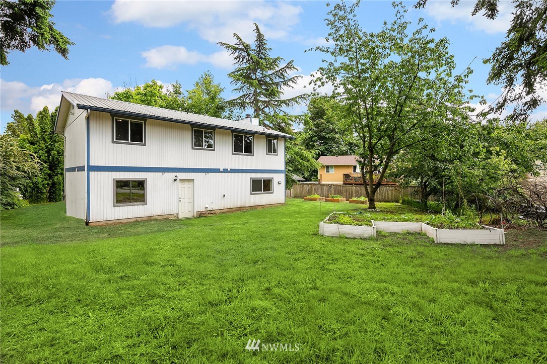 23818 1st Avenue West Bothell, WA 98021 - Photo 16 of 20 a view of a white house in front of a big yard with large trees