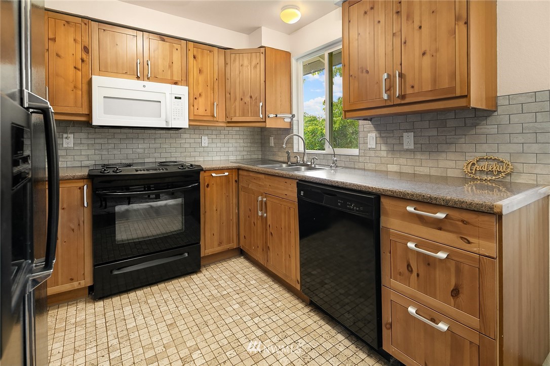 23818 1st Avenue West Bothell, WA 98021 - Photo 7 of 20 a kitchen with granite countertop a stove sink and cabinets