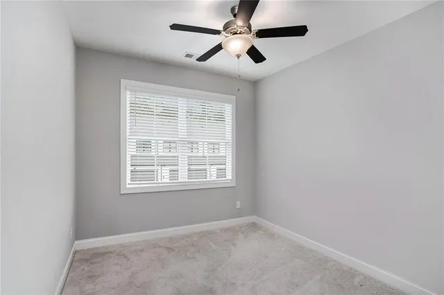 an empty room with a window and a fan