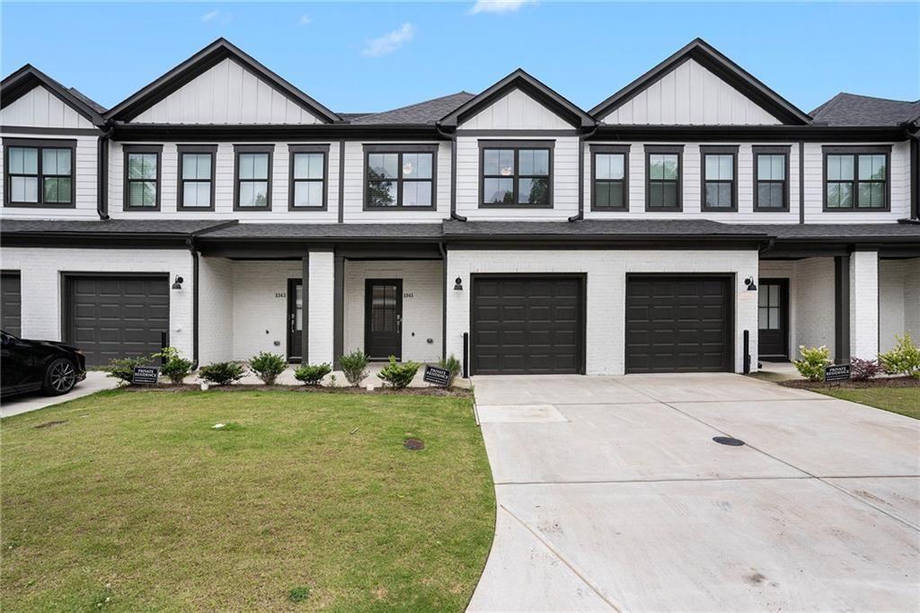 1341 Parc Bench Road Atlanta, GA 30316 - Photo 3 of 28 a front view of a house with a yard and garage